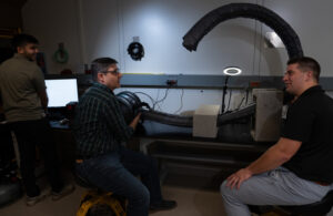 Left to right: Summer research intern Ankush Dhawan and Lincoln Laboratory staff members Chad Council and Nathaniel Hanson test a vine robot in a laboratory setting.