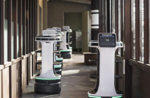 Bear Robotics' Servi Plus robots driving down a hallway.