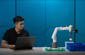 A person controlling the myCobot Pro 450 with a laptop.