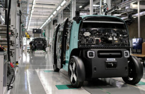 Zoox robotaxis moving through an assembly line.